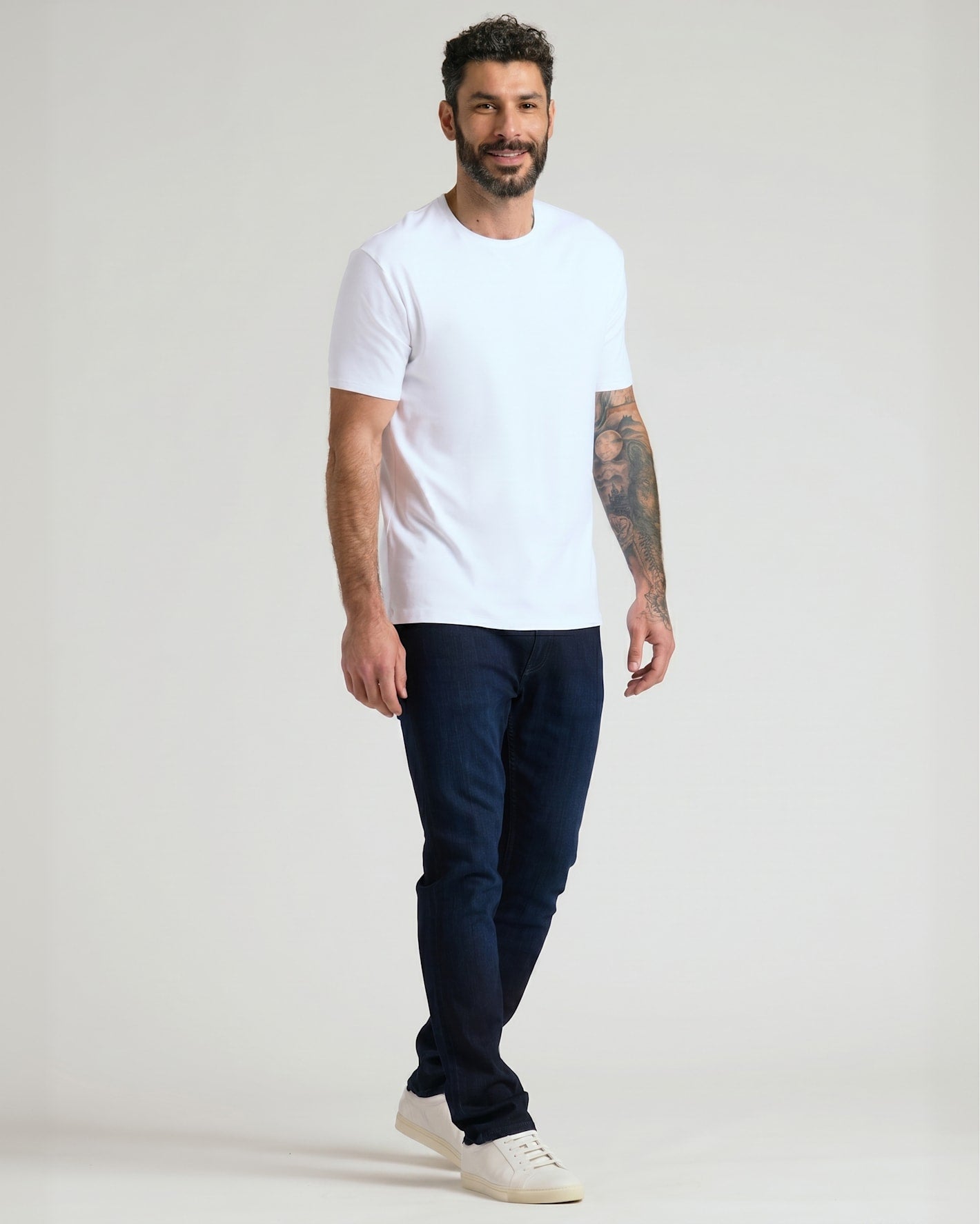 Man wearing Pima Cotton Blend Crew 4-Pack T-shirt, jeans, sneakers.