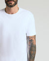 Man wearing a plain white crew neck t-shirt from the Pima Cotton Blend Crew 4-Pack, featuring short sleeves and a comfortable fit, showcasing a tattooed arm.