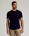 Man wearing Black Curved Hem Classic Crew Neck T-shirt with khaki pants.