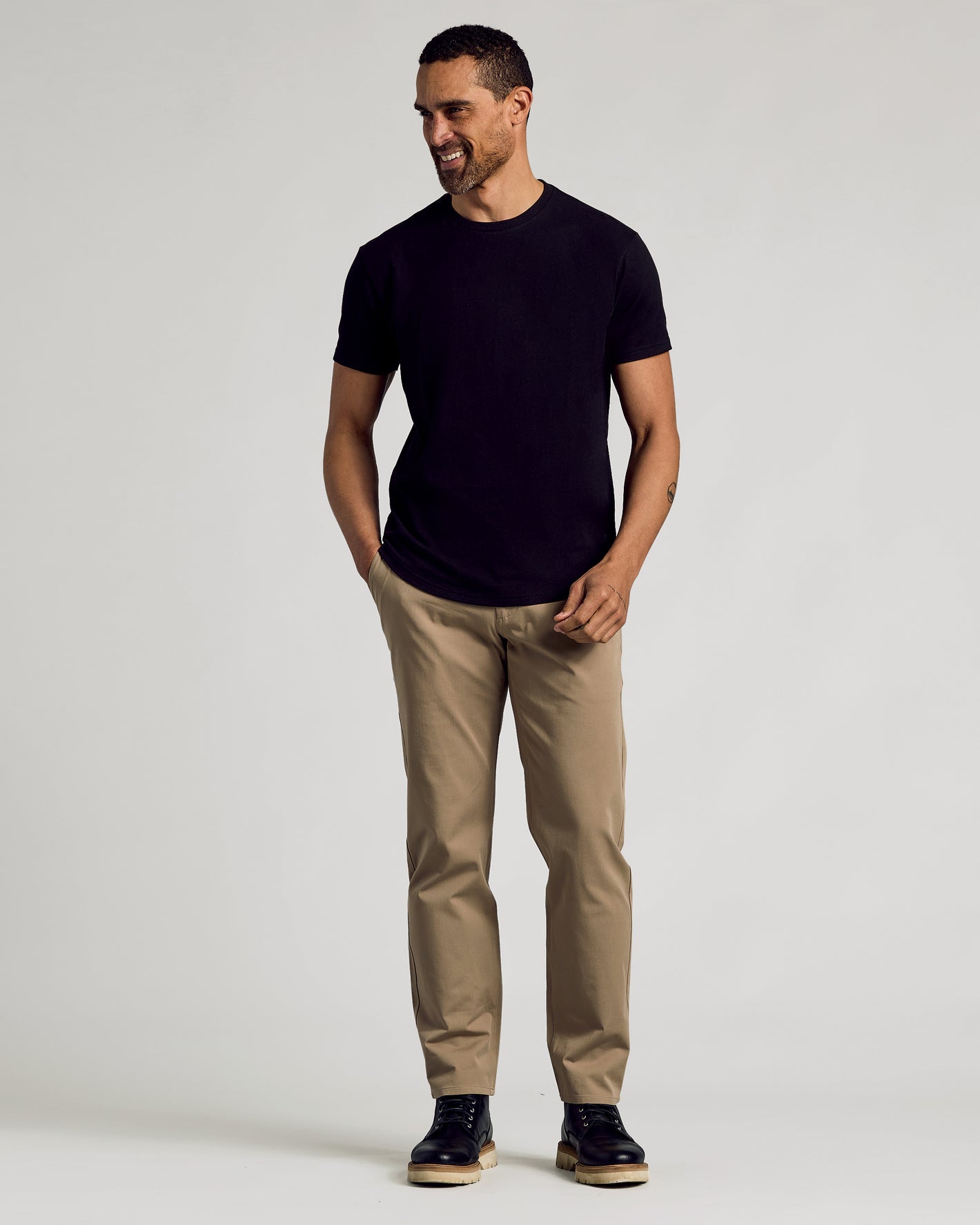 Man in Black Curved Hem Classic Crew Neck T-shirt, khaki pants.