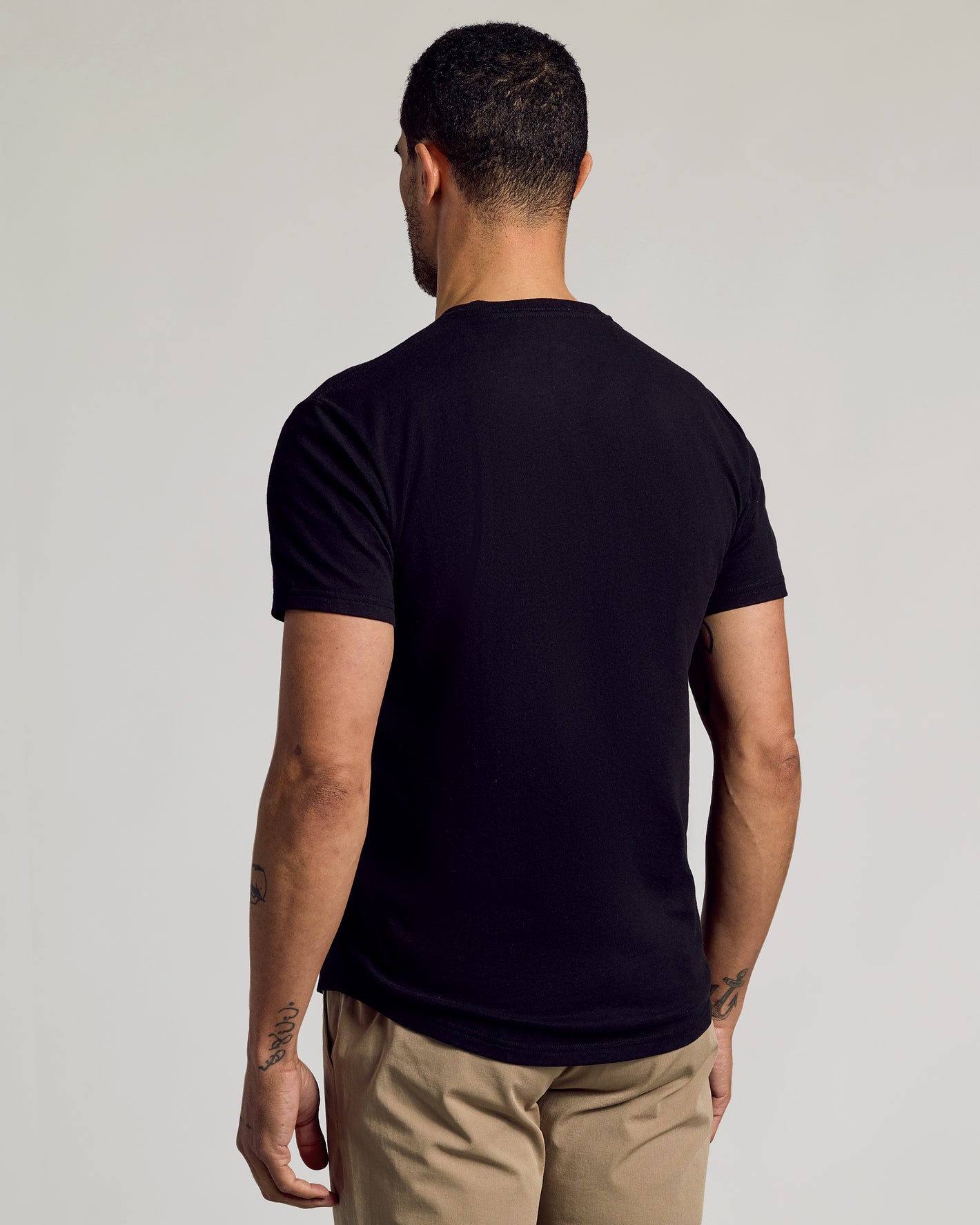 Black Curved Hem Classic Crew Neck 3-Pack worn by tattooed man, back view.