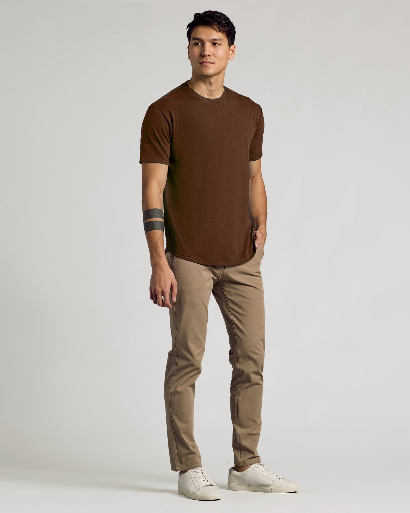 Carob Curved Hem Classic Crew Neck on young man, casual pose.