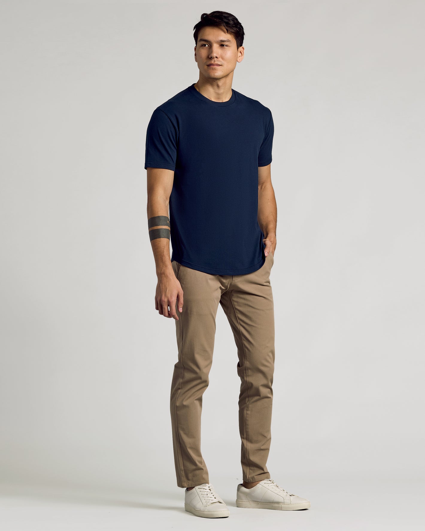 Young man wearing Navy Curved Hem Classic Crew Neck and khaki chinos.