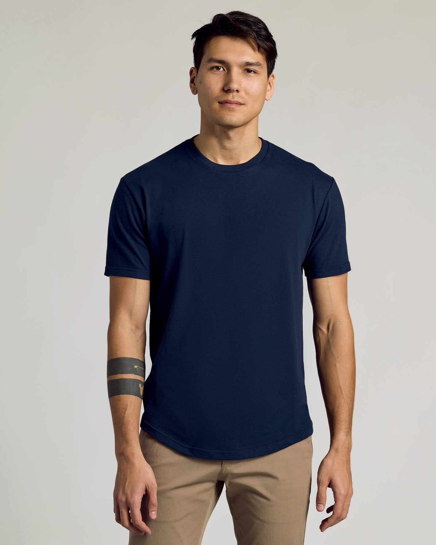 The Staple Curved Hem Classic Crew Neck on young man, relaxed posture.