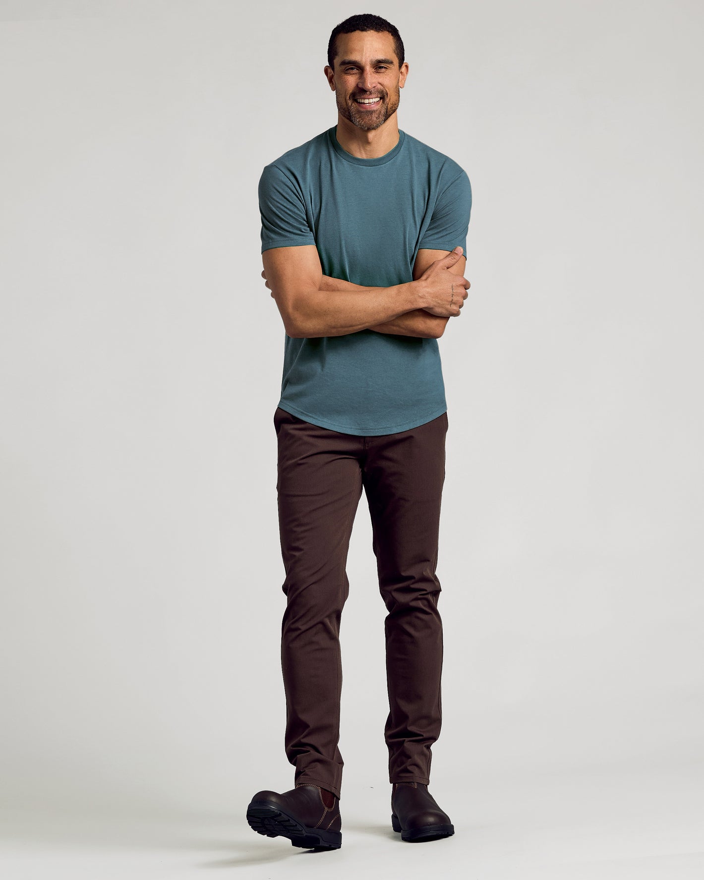 Man wearing Neptune Curved Hem Classic Crew Neck and dark brown pants.