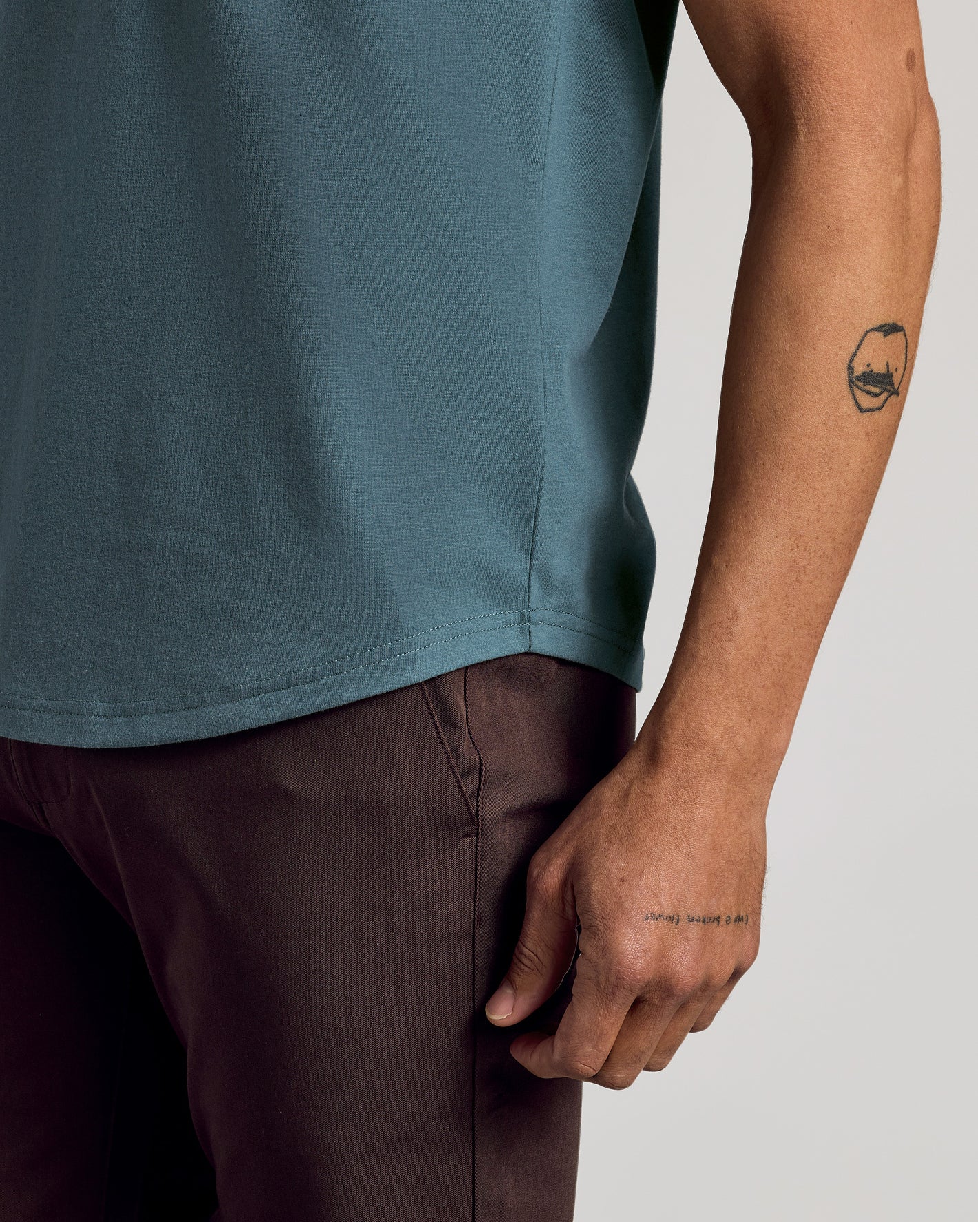Neptune Curved Hem Classic Crew Neck on tattooed forearm.