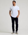Man wearing Wardrobe Curved Hem Classic Crew Neck T-shirt, slim black pants.