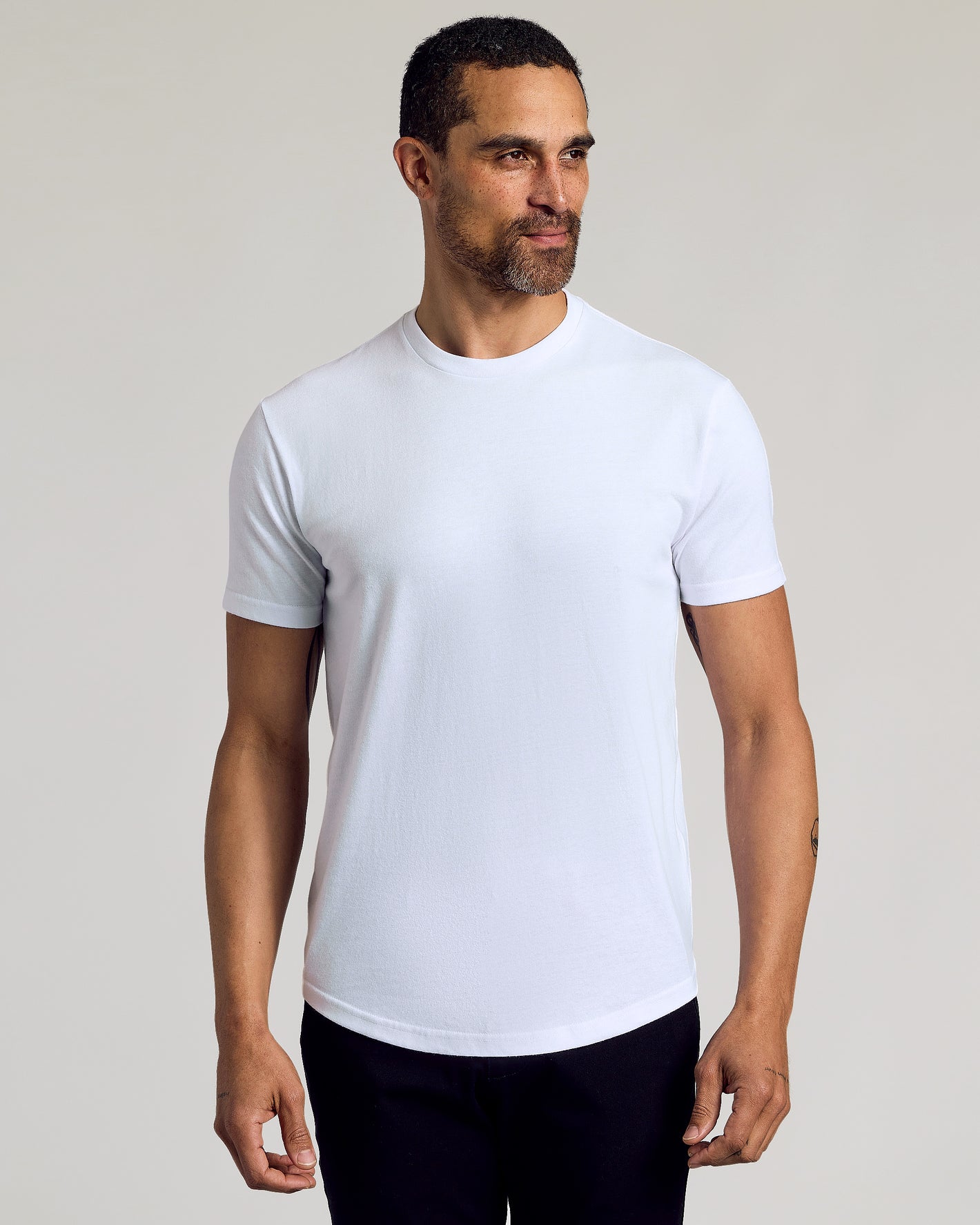 Man in The Staple Curved Hem Classic Crew Neck tee.