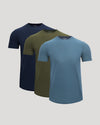 Three short-sleeve crew-neck t-shirts in navy blue, olive green, and slate blue, arranged in a staggered overlapping display on a light gray background.