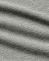 Close-up of a heather gray fabric texture with soft folds and a woven slub pattern.