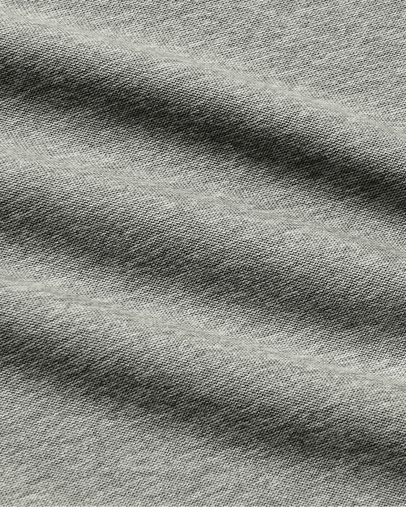 Close-up of a heather gray fabric texture with soft folds and a woven slub pattern.