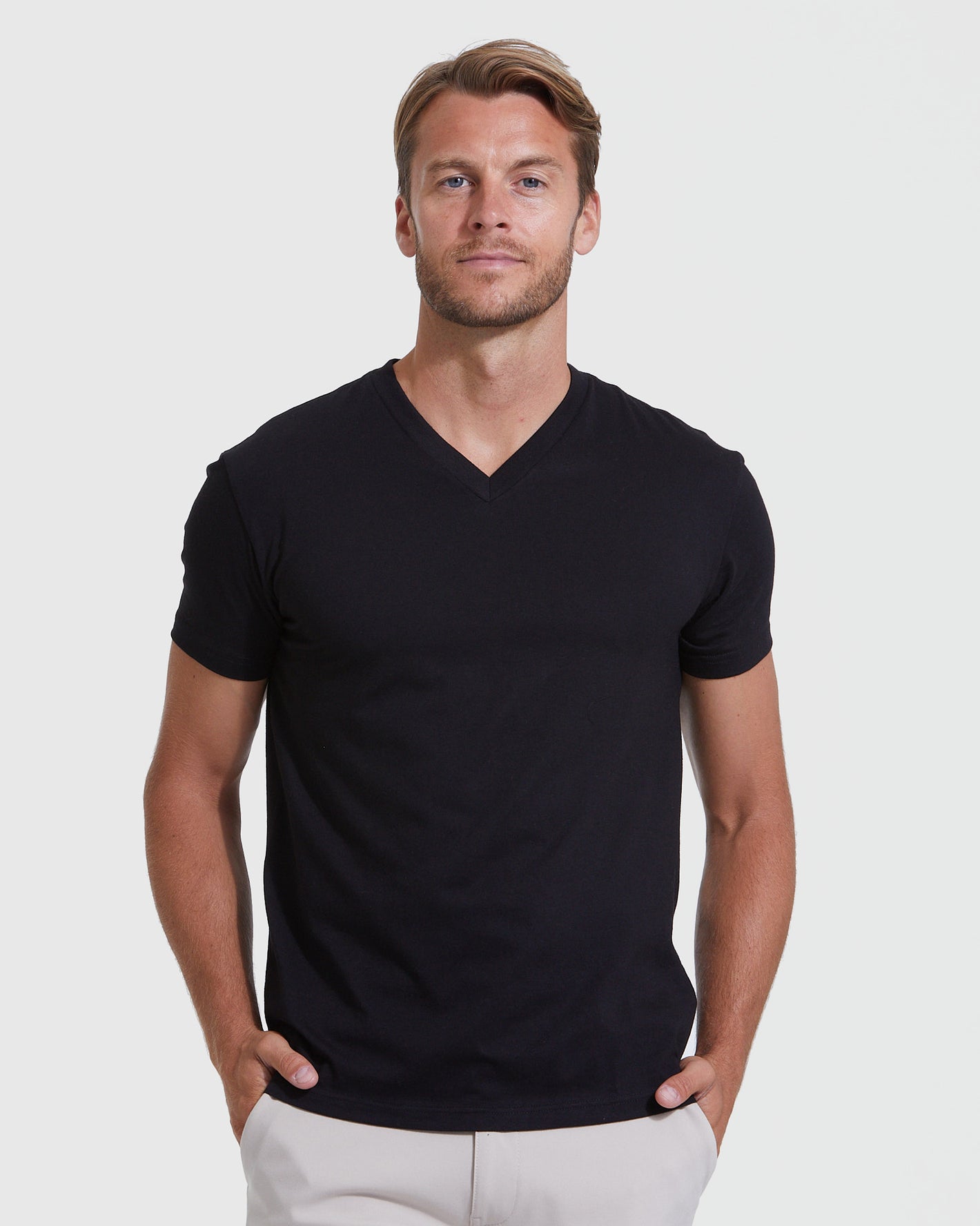 Man wearing Standard 3-Pack black V-neck T-shirt, hands in pockets.