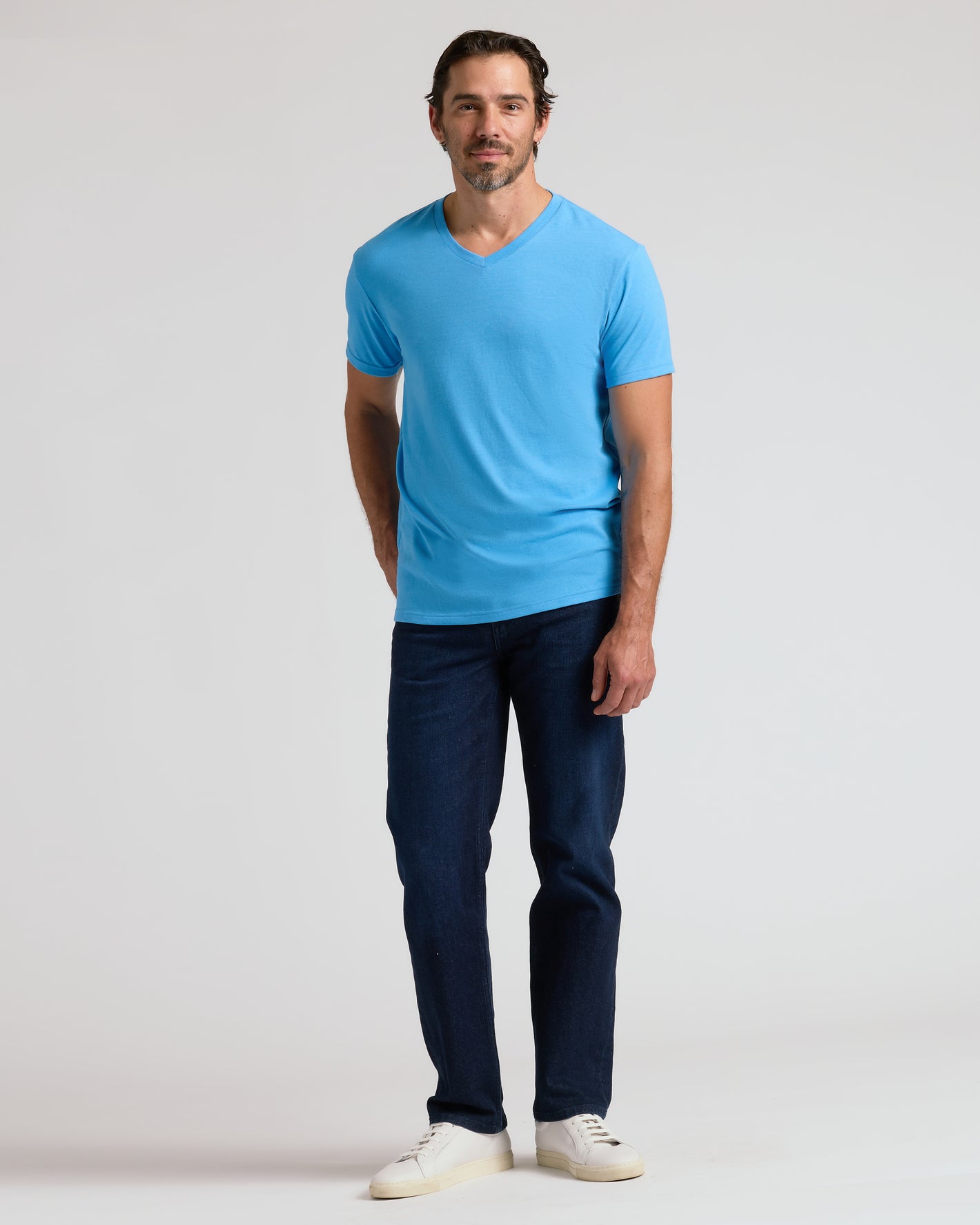 Man in Dark Heather Bahama Blue Classic V-Neck T-shirt and jeans.