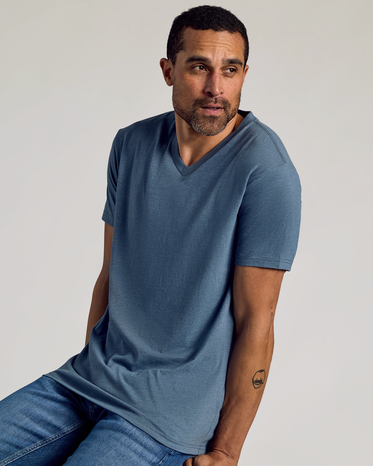 Man wearing Dark Heather Tempest Classic V-Neck T-shirt, showcasing its fit.