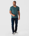 Man wearing Heather Seafarer Classic V-Neck, dark-blue jeans, black sneakers.