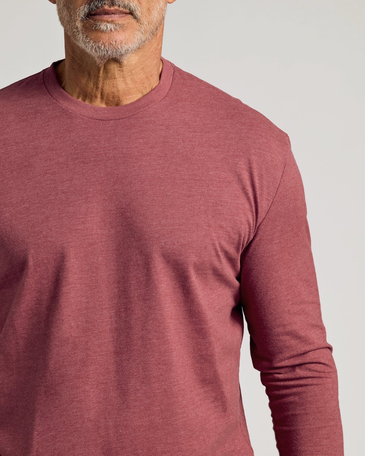 Man wearing Dark Heather Rustic Apple Classic Long Sleeve Crew Neck.