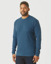 Man in Deep Sea Blue Long Sleeve T-Shirt and dark jeans.