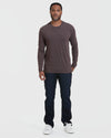 Man wearing Heather Dark Oak Classic Long Sleeve Crew Neck, dark jeans, white sneakers.