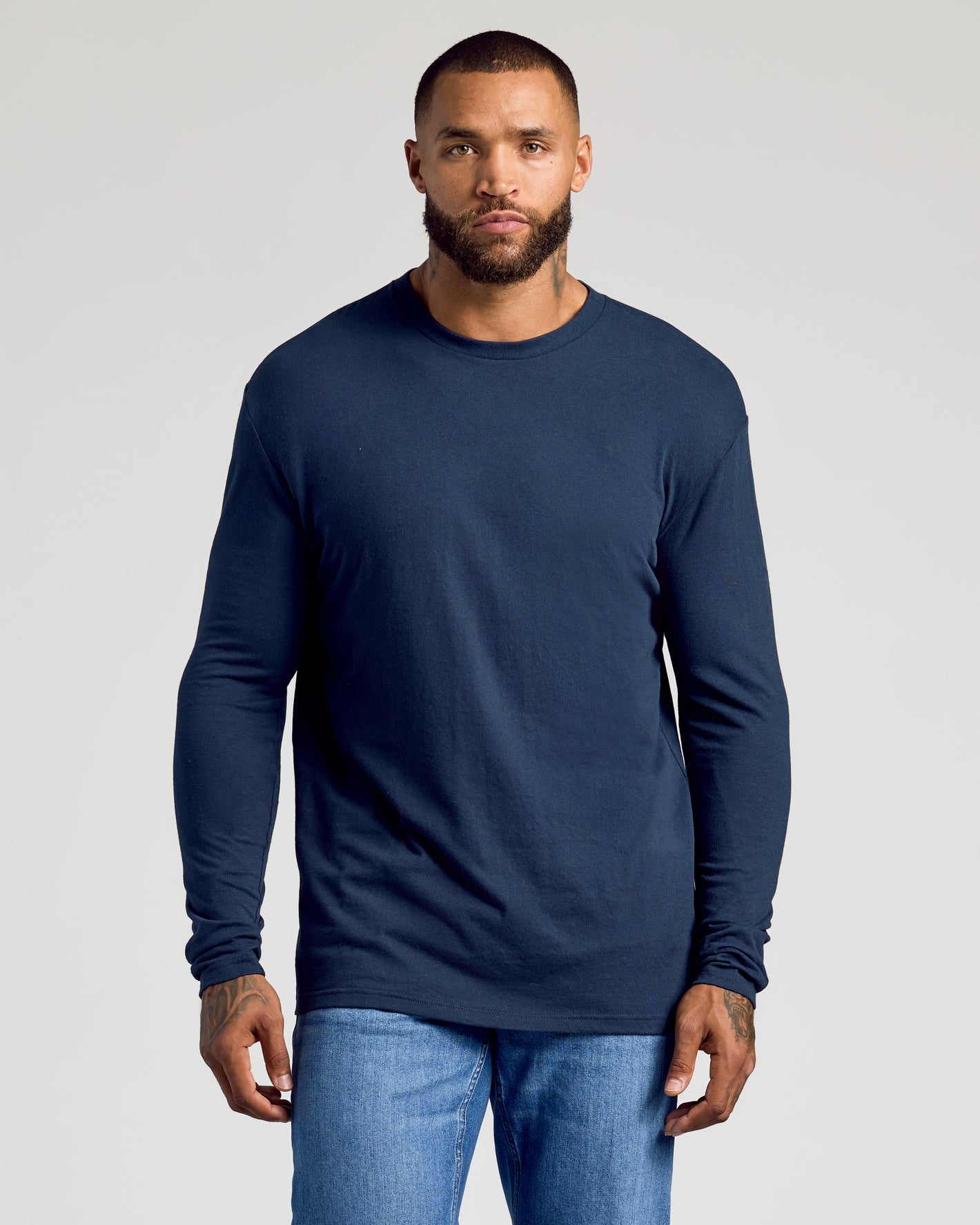 Man wearing Standard Long Sleeve Crew 3-Pack in navy and jeans.