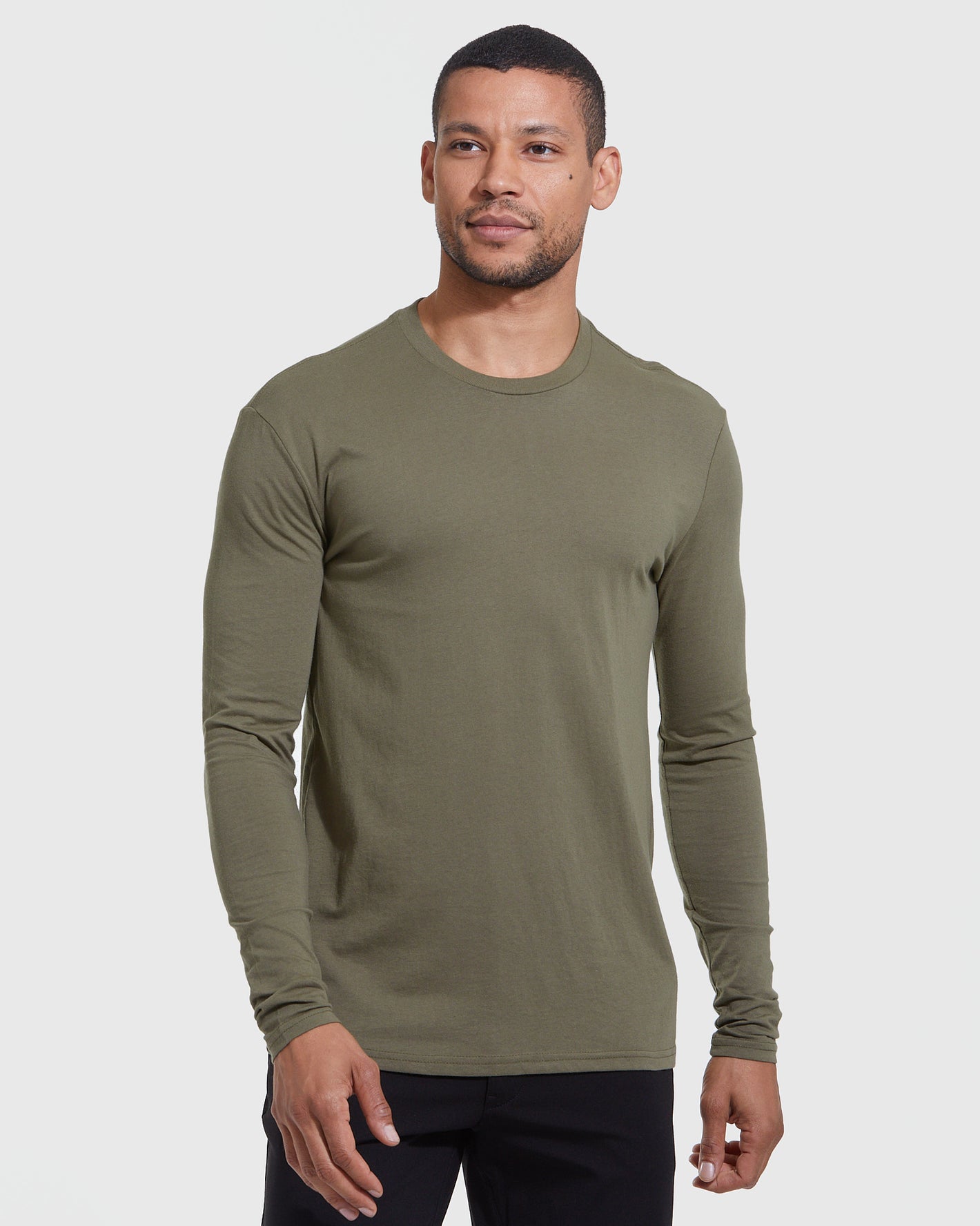Model wearing The Versatile Crew 9-Pack's olive-green long-sleeve tee.