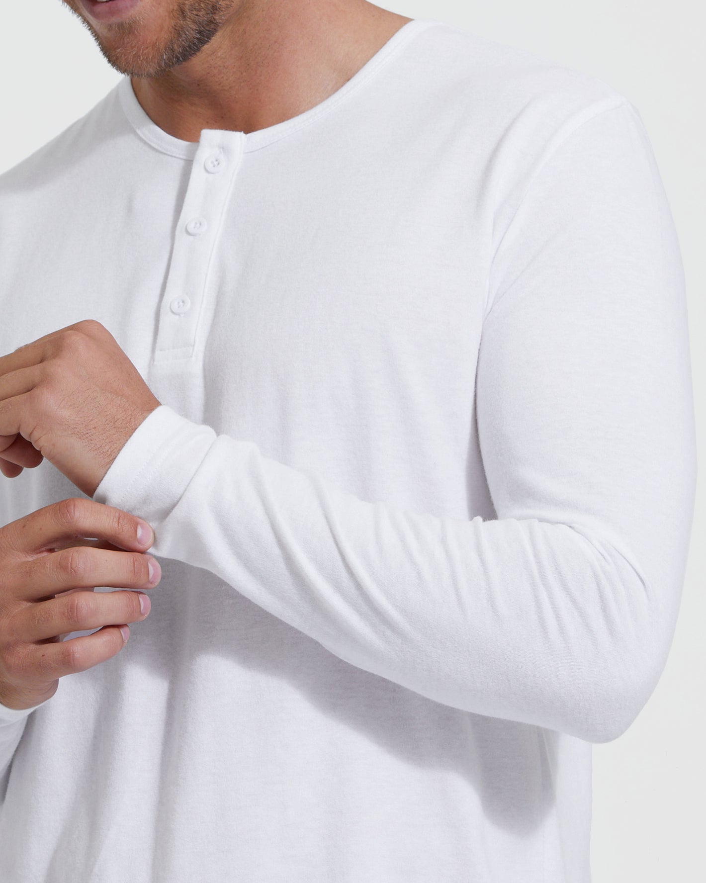 Man adjusting sleeves of All White Classic Henley.