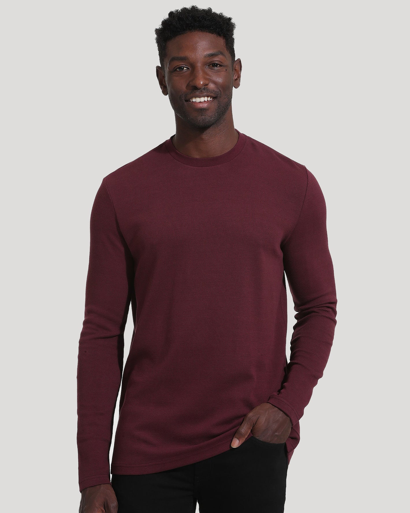 Man wearing Mahogany Long Sleeve Waffle Crew, smiling casually.