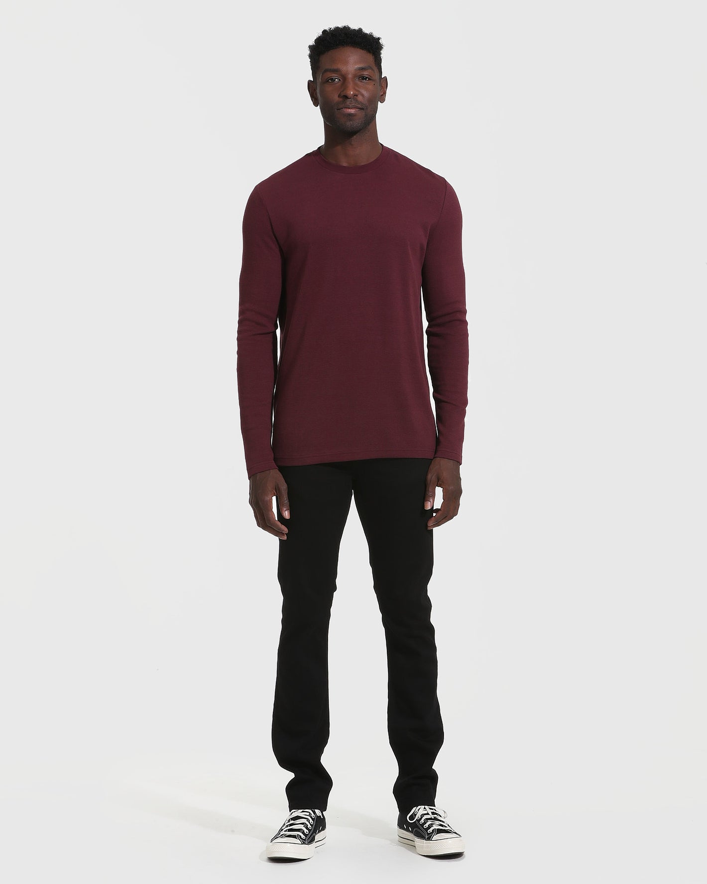 Man wearing Mahogany Long Sleeve Waffle Crew with black pants and sneakers.