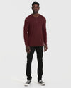 Man wearing Mahogany Long Sleeve Waffle Henley with slim-fit black pants.