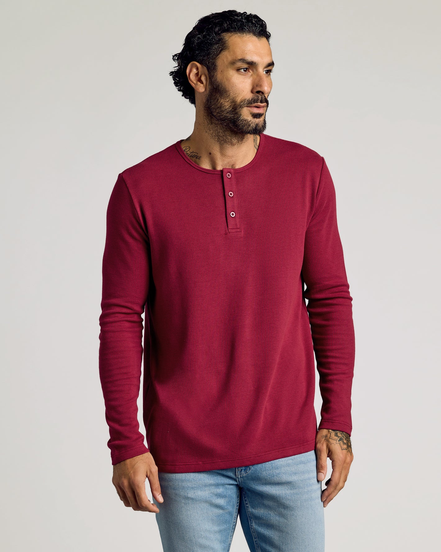 Man wearing Pinot Waffle Long Sleeve Henley, showcasing textured, fitted design.