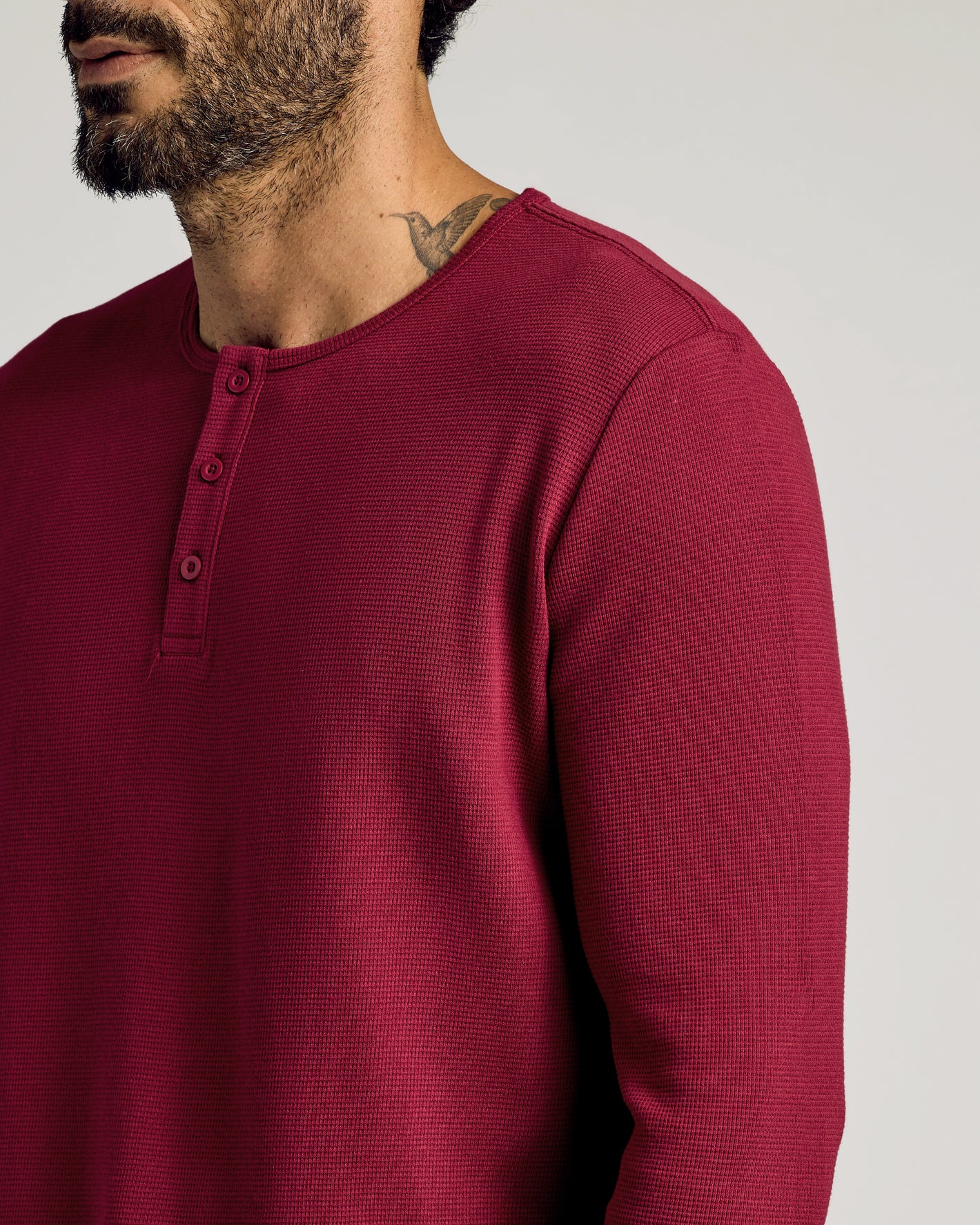 Man wearing Pinot Waffle Long Sleeve Henley with neck tattoo visible.