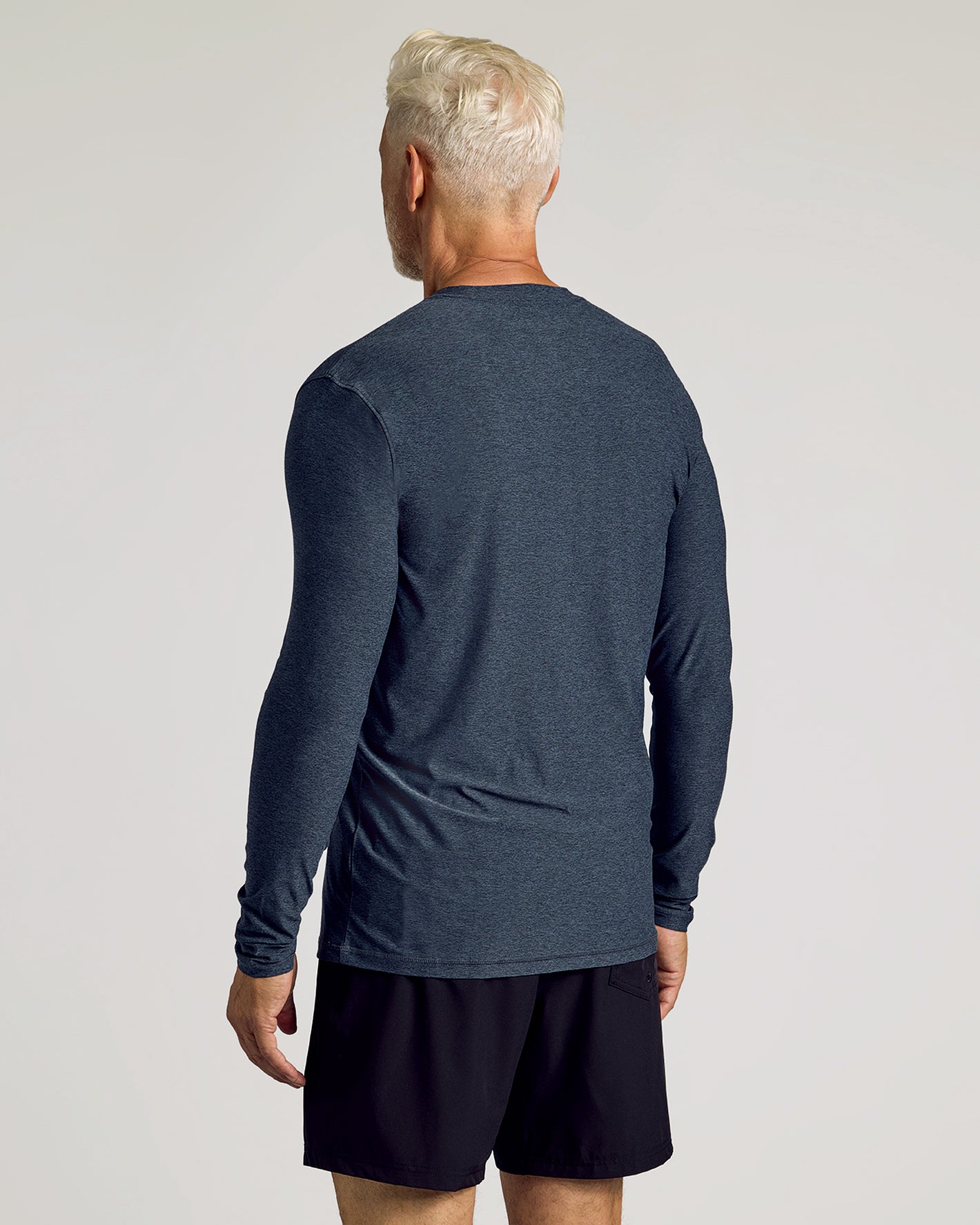 Man in Dark Heather Fiord Active Long Sleeve Crew T-Shirt, relaxed stance.