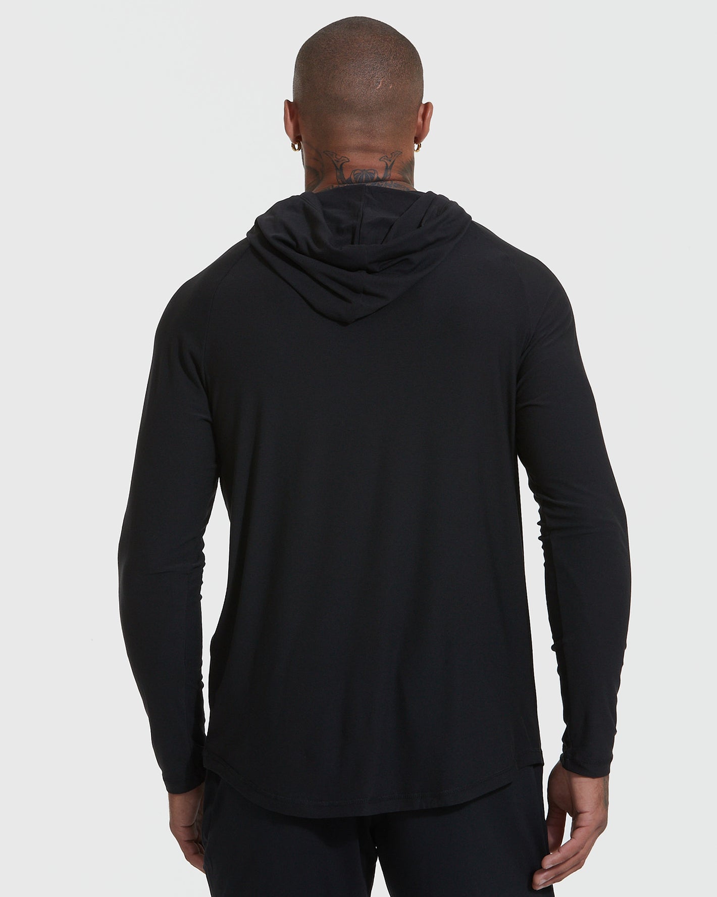 Black Active Hoodie worn by person, hood down, showcasing sleek fit and design.