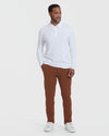 White Long Sleeve Polo worn by man with rust-brown trousers.