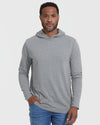 Man wearing Heather Gray Hooded Long Sleeve T Shirt, hands in pocket.