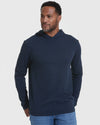 Man in Navy Hooded Long Sleeve T-Shirt against gray background.
