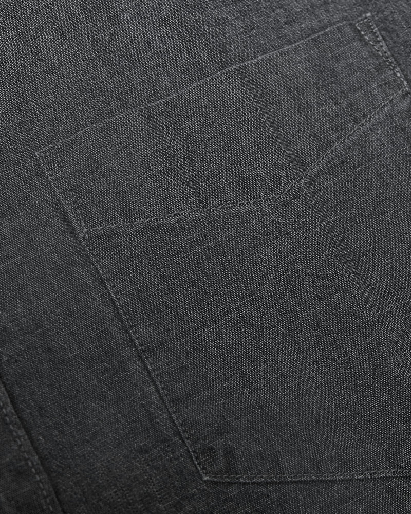 Black Wash Long Sleeve Chambray Shirt fabric close-up with pocket stitching.