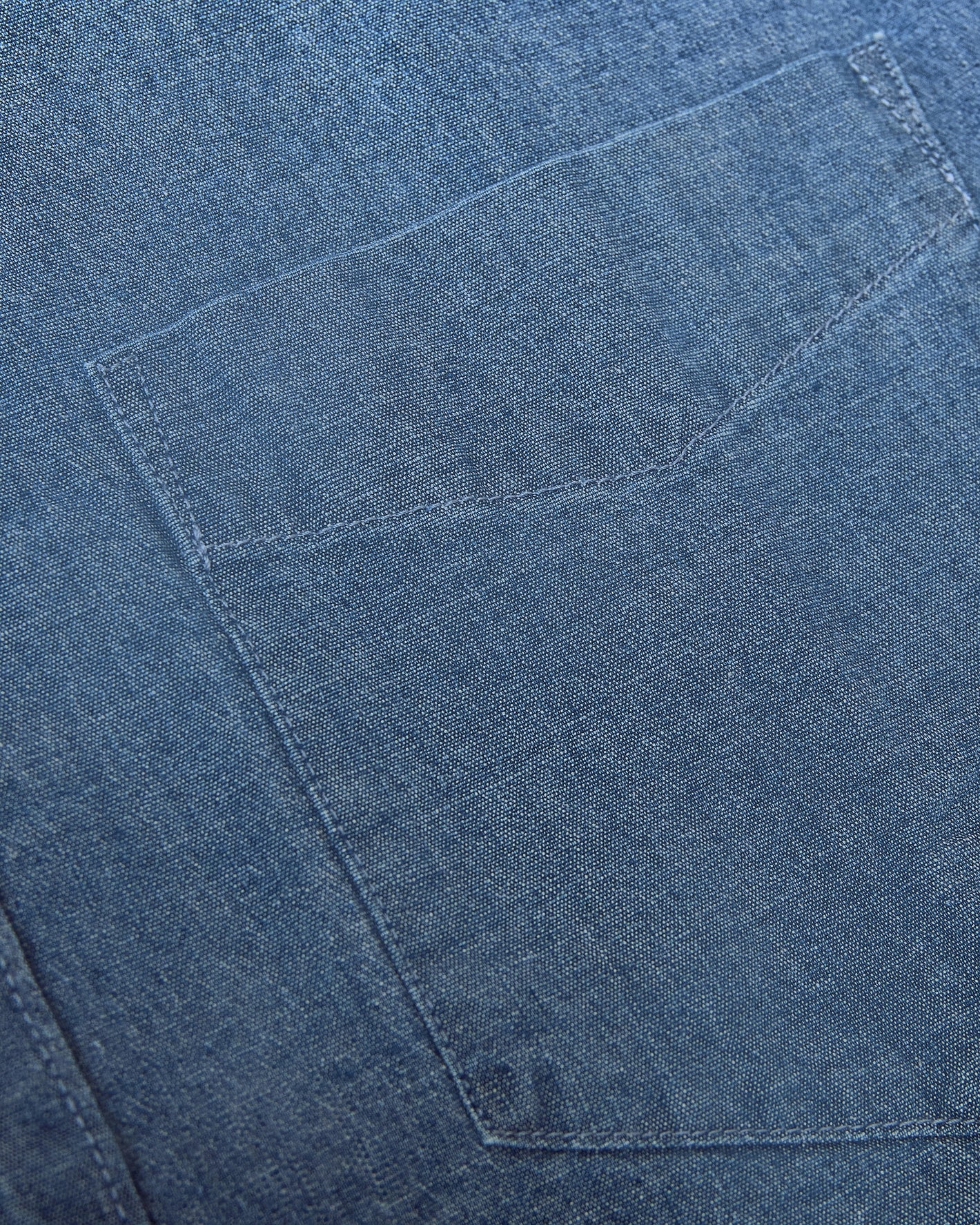 Light Indigo Wash Long Sleeve Chambray Shirt close-up of denim pocket stitching.