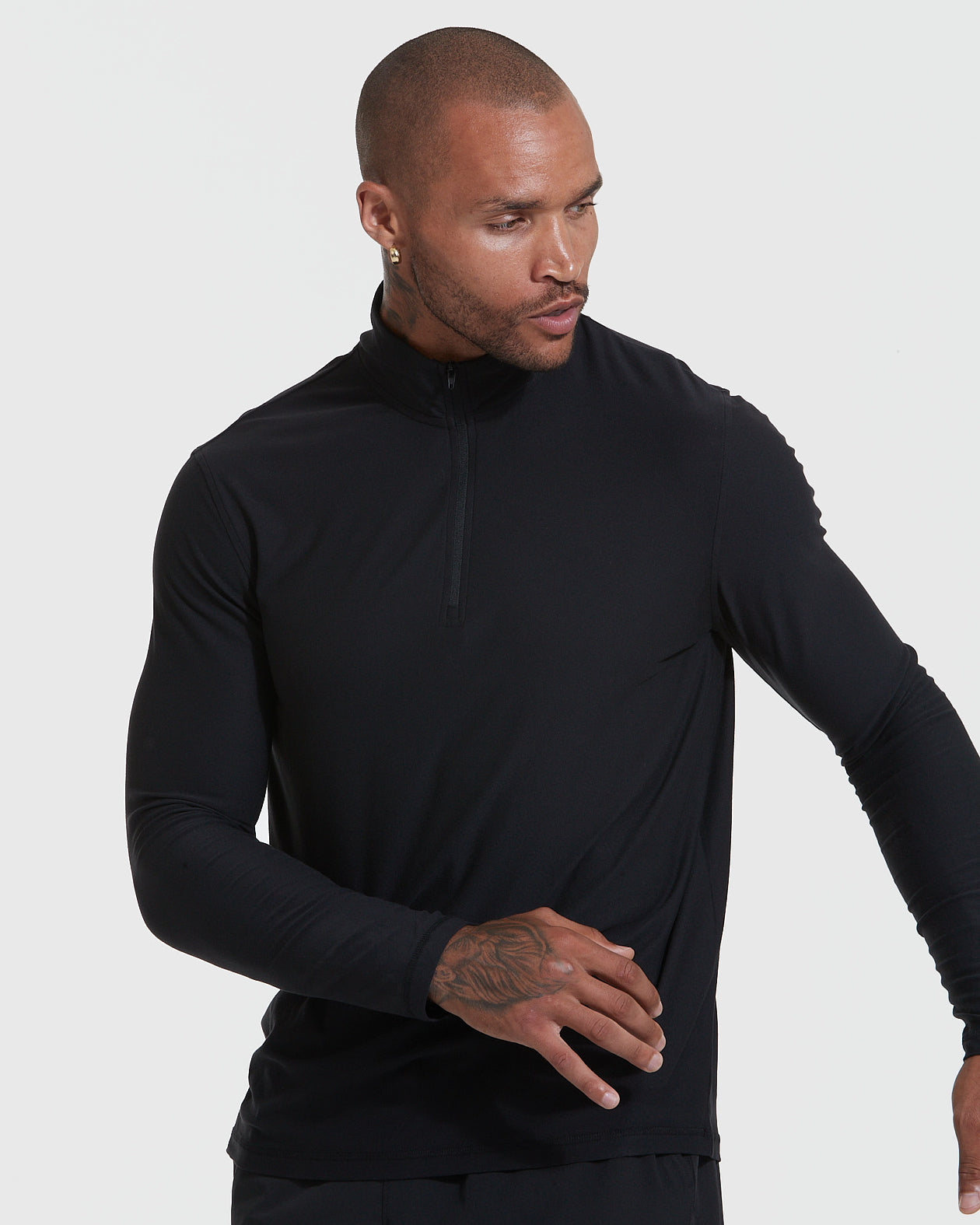 Man modeling Black Active Quarter Zip Shirt, showcasing tattooed hand and earring.