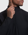 Black Active Quarter Zip Shirt showcasing hand on zipper, tattooed neck.