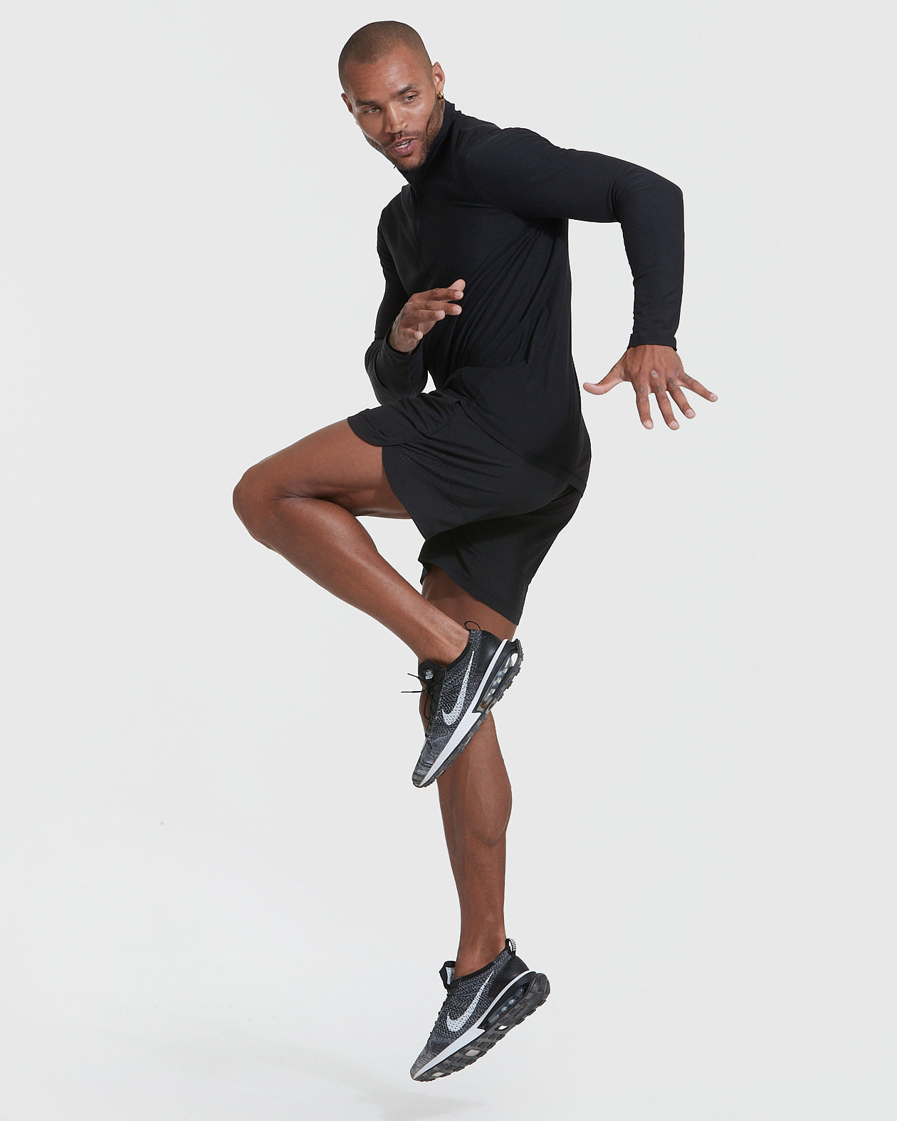 Man jumping in Black Active Quarter Zip Shirt, showcasing athletic features.