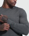 Man adjusts sleeve of Charcoal Heather Active Comfort Crew Sweatshirt, showcasing tattoos.