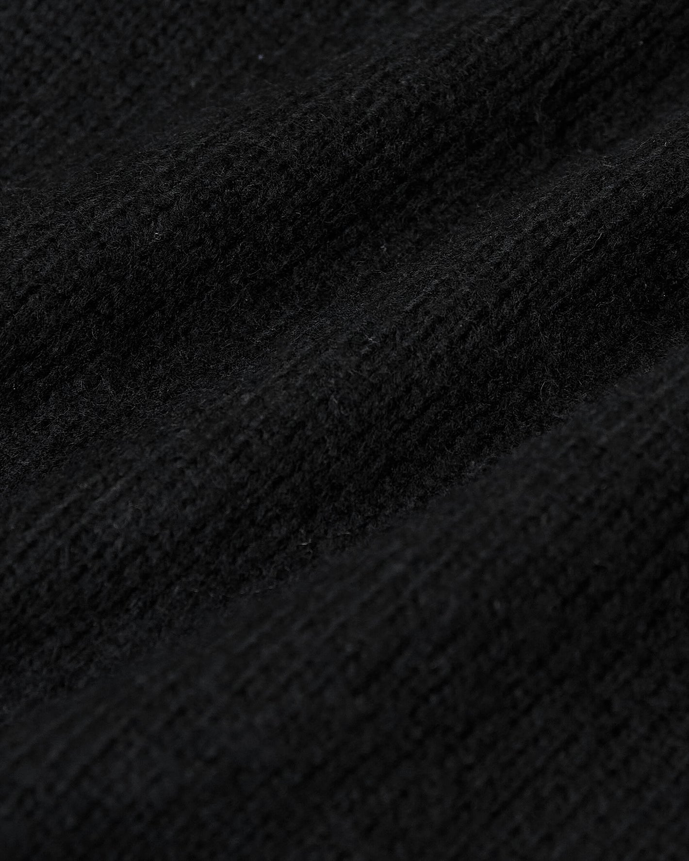 Black Crew Neck Sweater showcasing textured knit fibers and ribbed detailing.