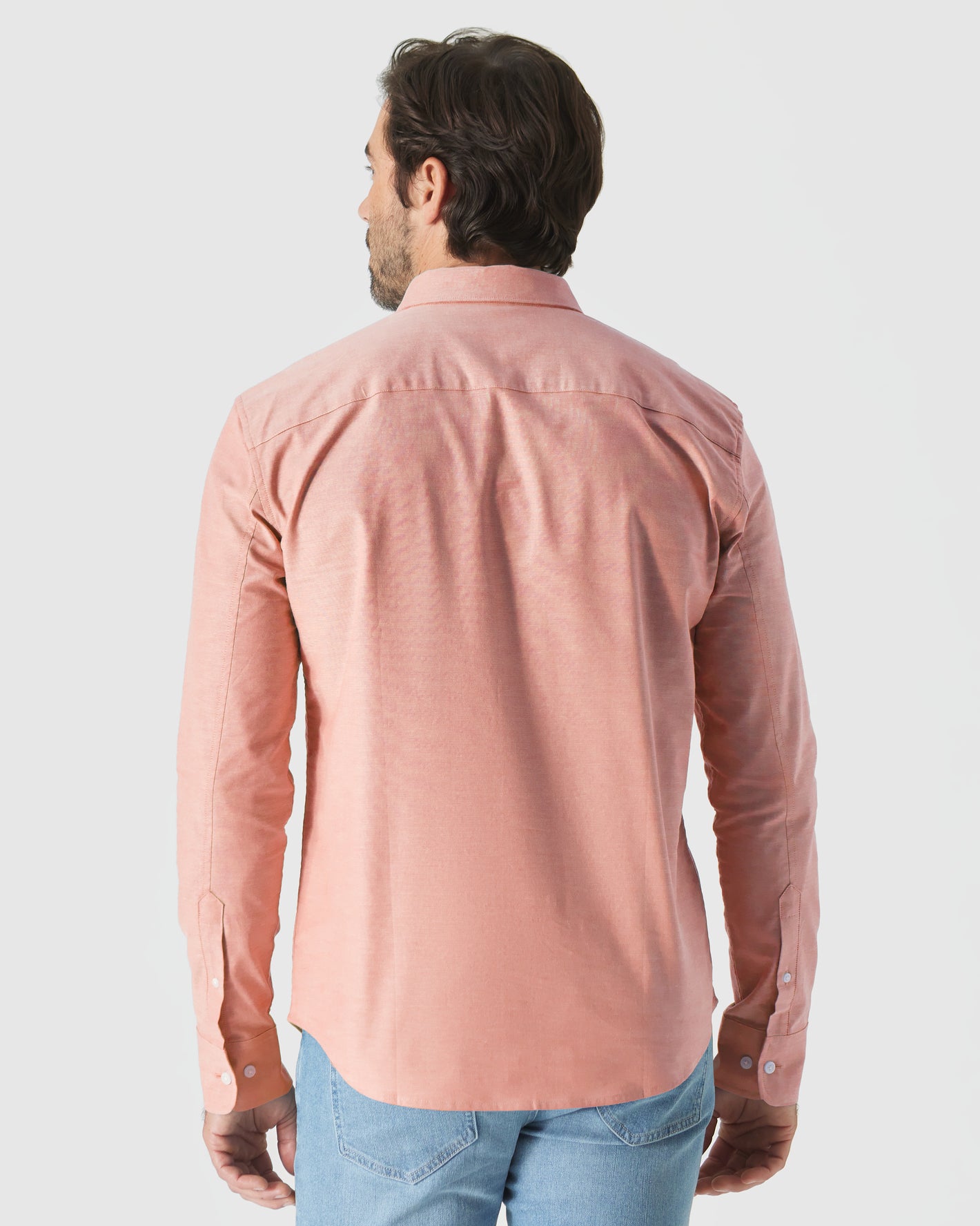 Man wearing Peach Long Sleeve Oxford Shirt with jeans, back view.
