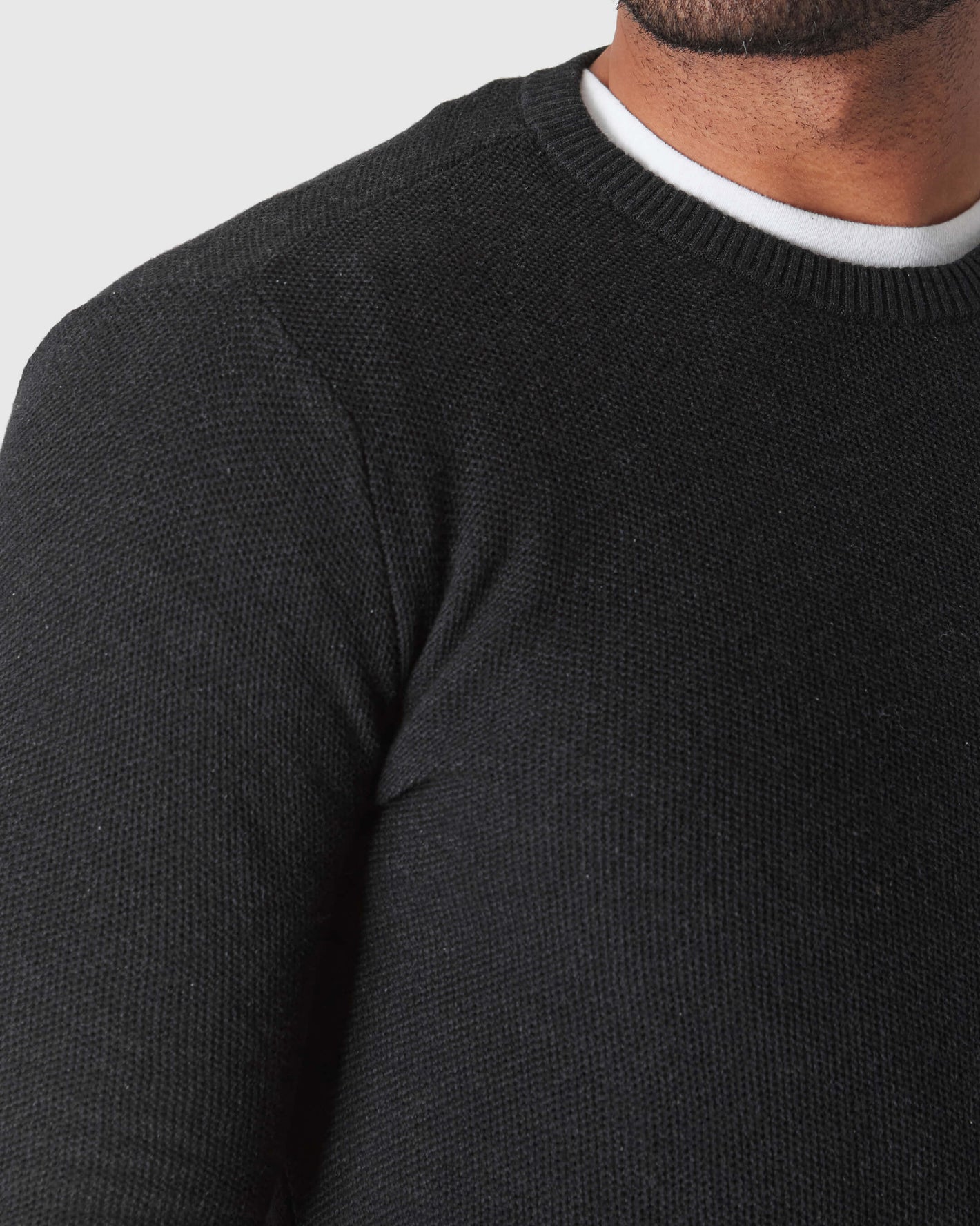 Man wearing Charcoal Heather Gray Pique Crew Sweater over a white tee.