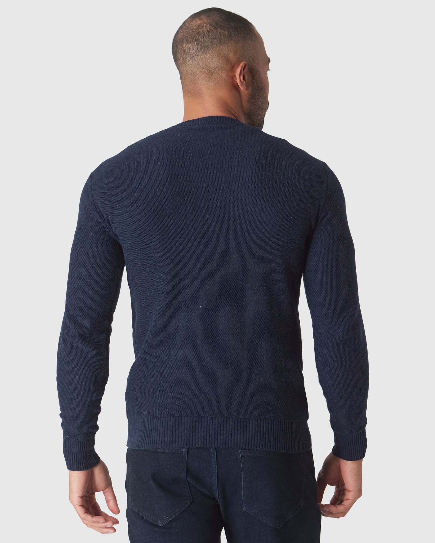 Heather Navy Pique Crew Sweater, back view on model, arms relaxed.