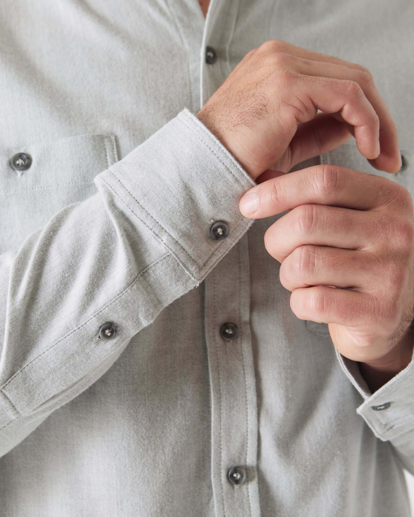 Adjusting cuff of Heather Gray Long Sleeve Lightweight Flannel Shirt.