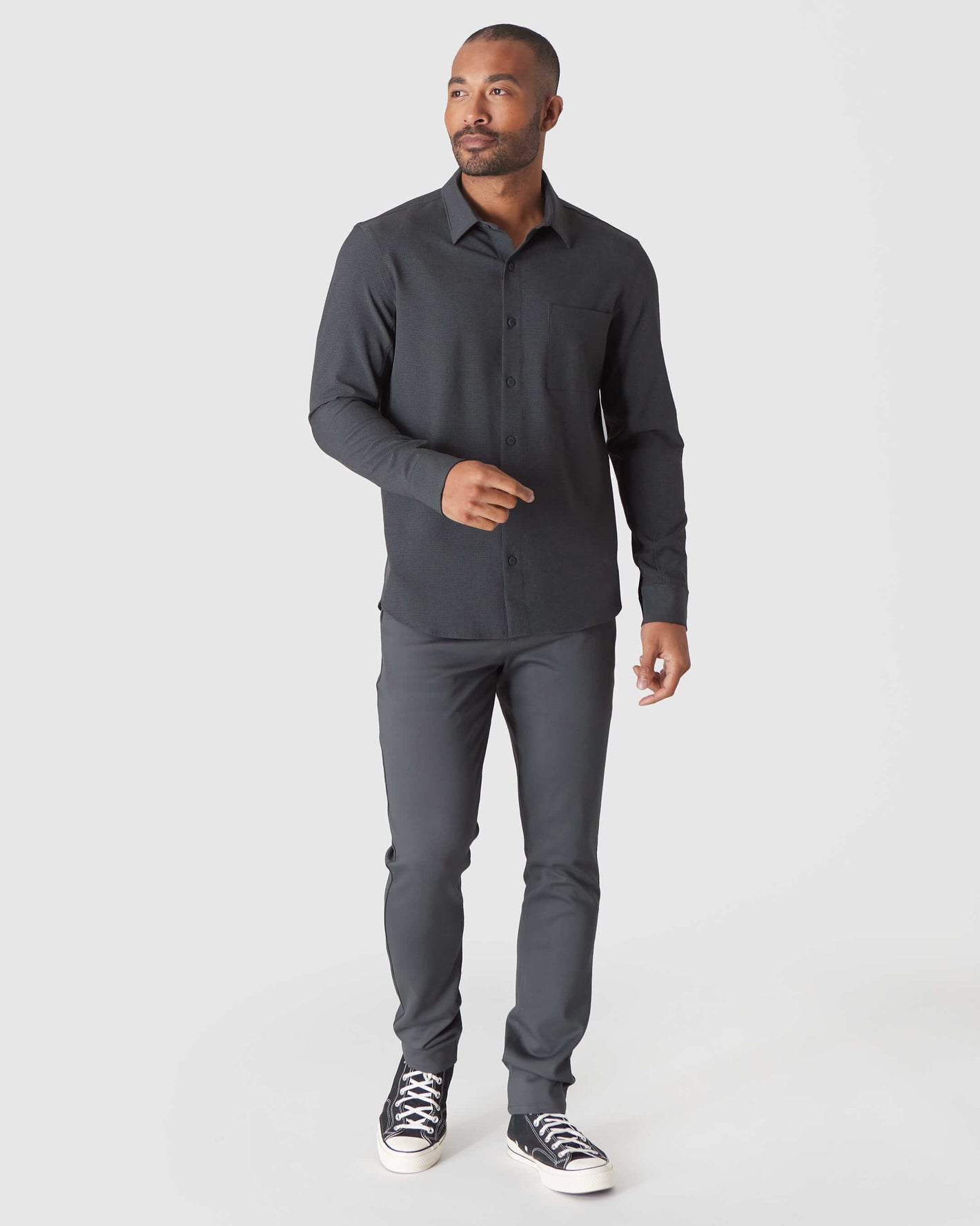 Man in Charcoal Heather Gray Long Sleeve Ripstop Commuter Shirt stepping forward.