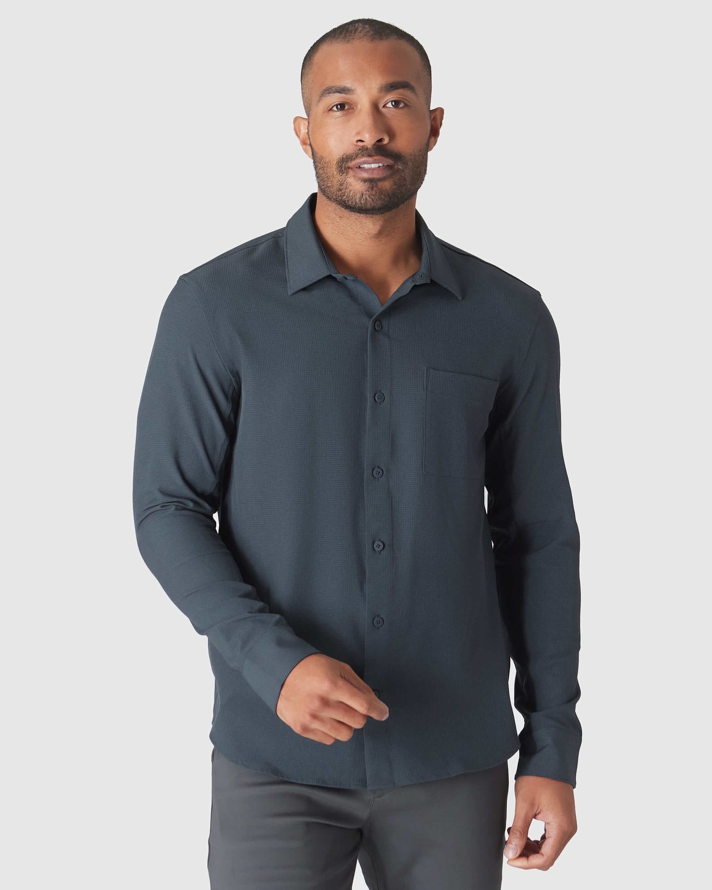 Man wearing Heather Navy Long Sleeve Ripstop Commuter Shirt gesturing.