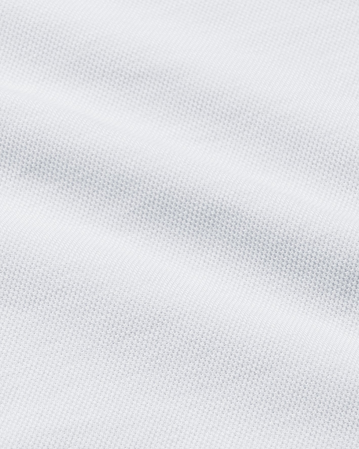 White Stretch Oxford 2.0 fabric, showcasing textured piqué knit and gentle folds.