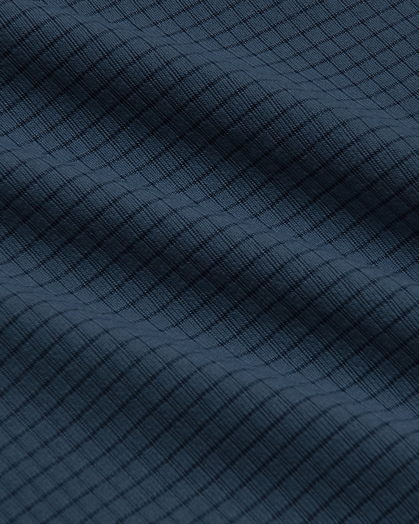 Close-up of Sleeveless Active Mesh Tank's textured dark blue fabric.
